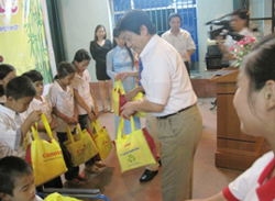 Đại diện Sở LĐTBXH tỉnh Bắc Giang và công ty Canon Việt Nam tặng quà cho các em nhỏ