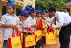 Đại diện công ty TNHH Canon Việt Nam trao quà cho từng em học sinh