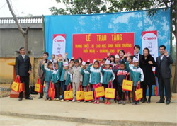Hiệu trưởng cùng đại diện Canon Việt Nam và lãnh đạo địa phương tặng quà cho các em học sinh