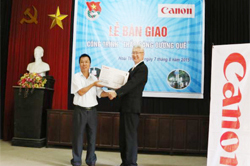 Đại diện công ty TNHH Canon Việt Nam trao quà và biển tượng trưng cho các thôn